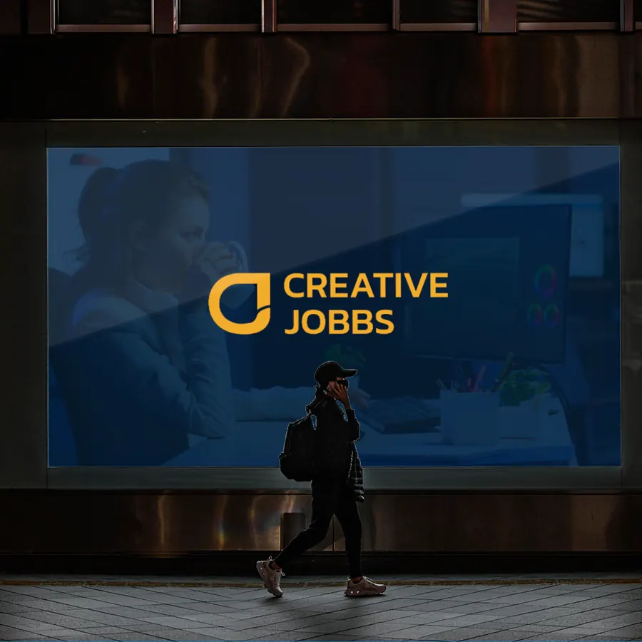 Creative Jobbs logo on a studio window with a passer-by